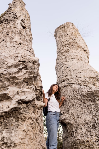 Free photo front view woman standing between rocks