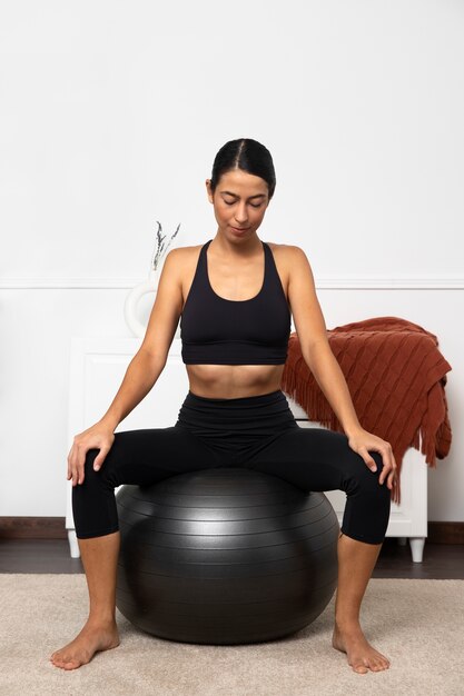 Front view woman strengthening the pelvic floor with ball