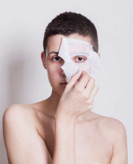 Front view woman taking off her face mask