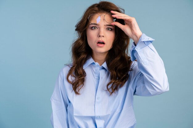 Front view of woman taking off her glasses in shock