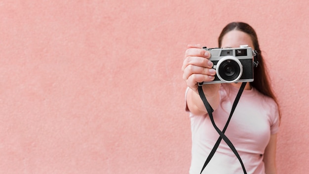 Front view of woman taking a picture with camera and copy space