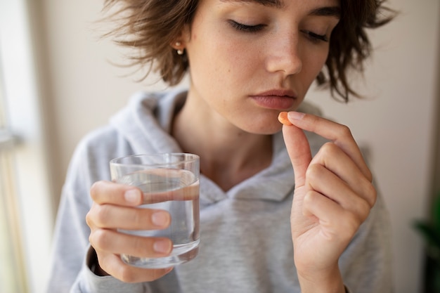 Front view woman taking pill