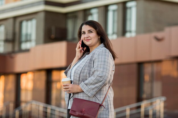 Front view woman talking on the phone outdoors