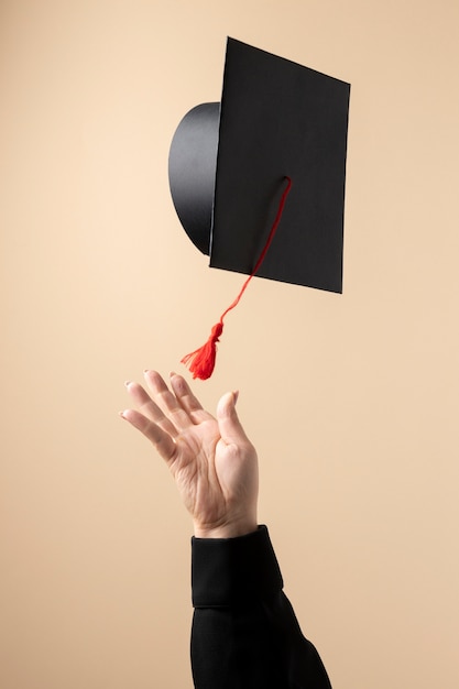 Front view of a woman throwing a graduation cap for education day