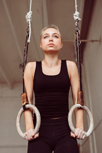 Front view woman training on gymnastics rings