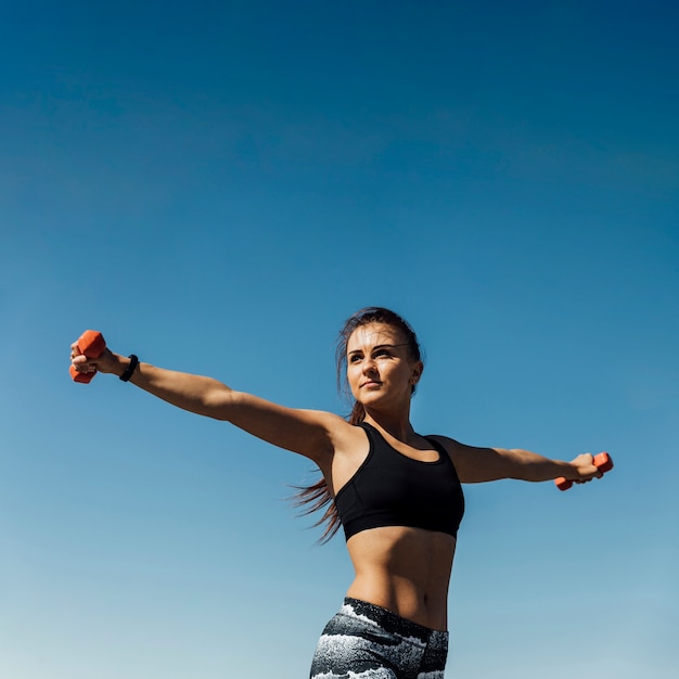 Front view of woman training with weights