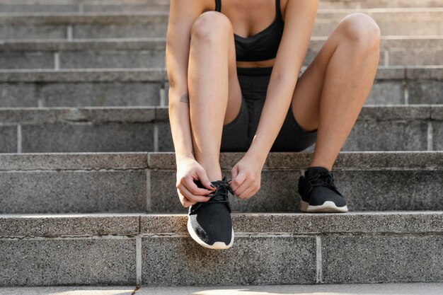 Front view of woman tying her shoelaces before exercising