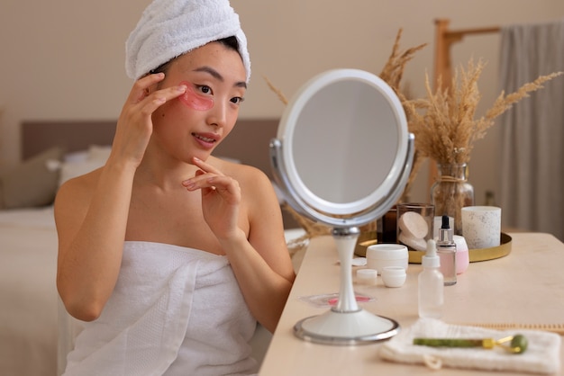 Free photo front view woman using eye patches