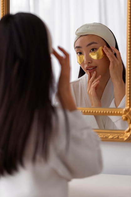 Free photo front view woman using eye patches