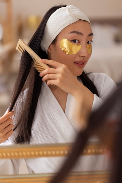 Free photo front view woman using eye patches