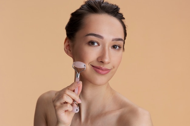 Front view woman using face roller