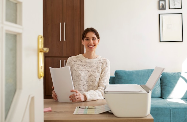 Foto gratuita donna di vista frontale che utilizza la stampante al lavoro