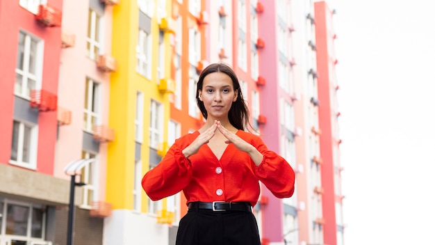 Free photo front view of woman using sign language outdoors