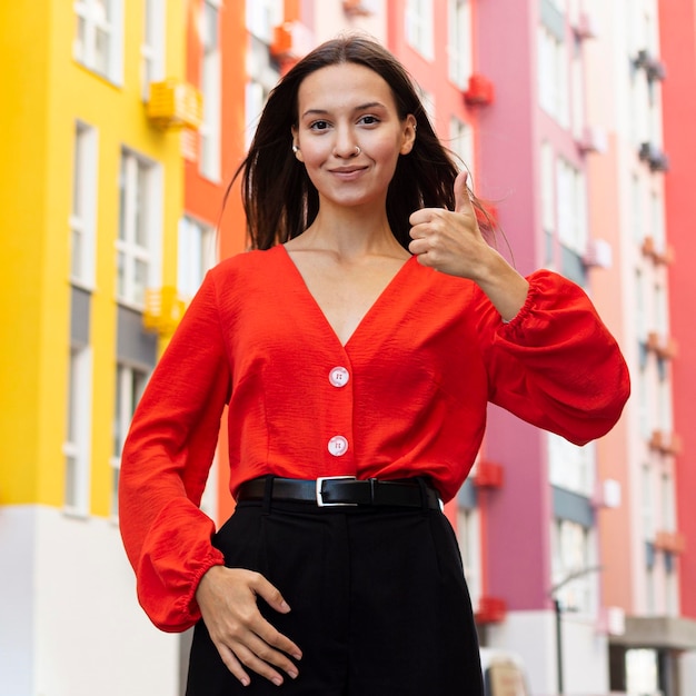 Foto gratuita vista frontale della donna che utilizza il linguaggio dei segni all'esterno