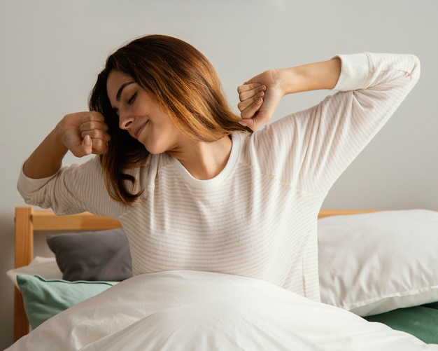 Front view of woman waking up at home