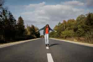 Free photo front view of woman walking in the middle of the road