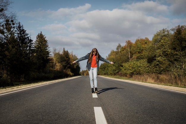 Front view of woman walking in the middle of the road
