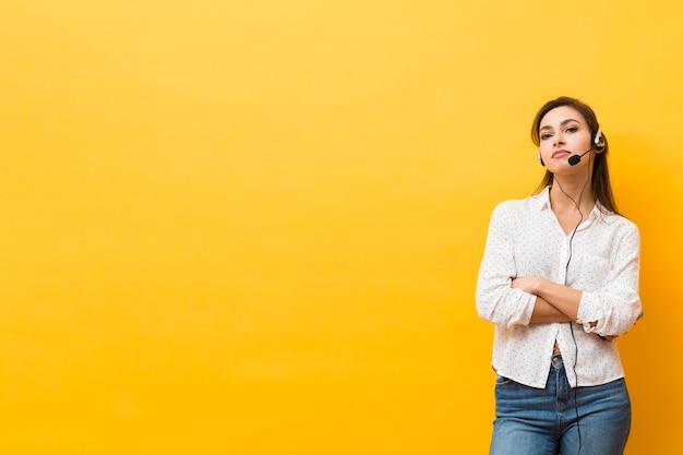 Free photo front view of woman wearing headset posing with arms crossed