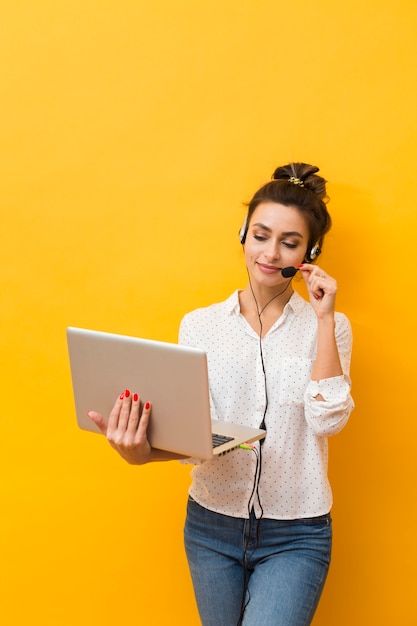 Front view of woman wearing headset taking to clients on laptop