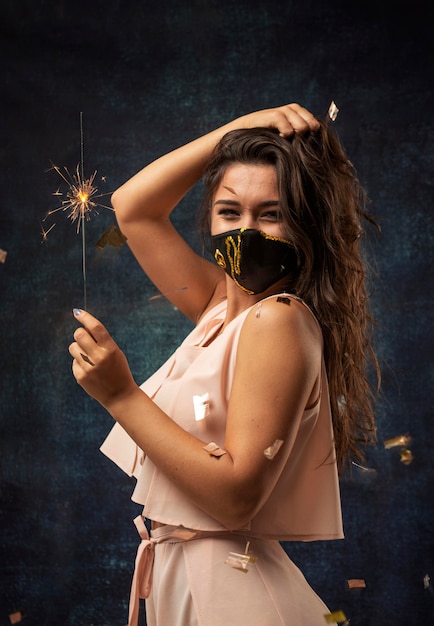 Free photo front view of woman wearing a mask with a firework