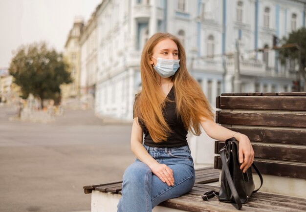 front view woman wearing a medical mask outside