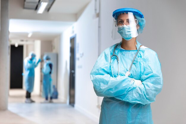 Front view woman wearing protective wear in the hospital