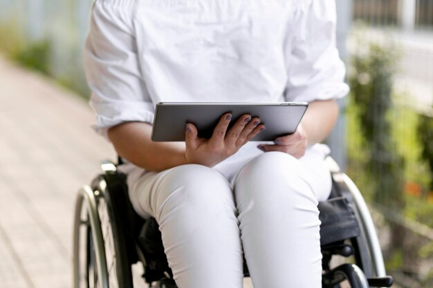 Front view of woman in wheelchair with tablet