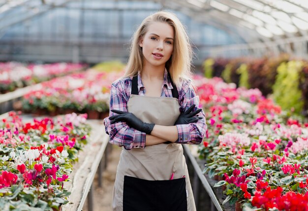 花の世話をするエプロンを持つフロントビュー女性