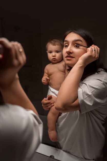 バスルームで赤ちゃんと正面図の女性