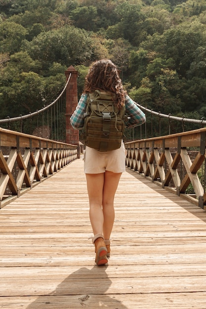 Foto gratuita donna di vista frontale con lo zaino sul ponte