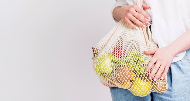 Front view of woman with bag of fruits