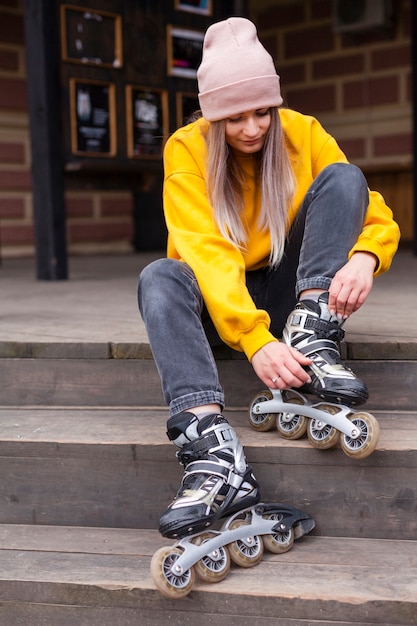 Front view of woman with beanie looking at roller blades