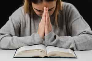 Free photo front view of woman with bible praying