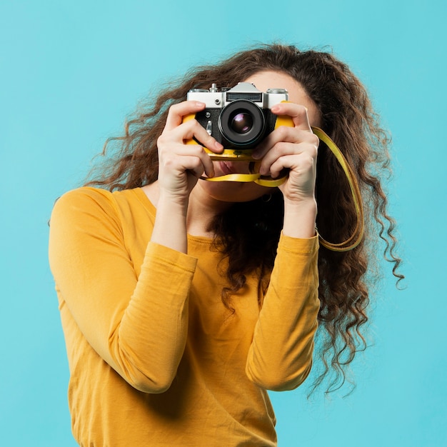 Foto gratuita vista frontale della donna con la macchina fotografica