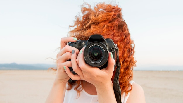 Free photo front view woman with camera