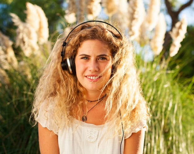 Front view of woman with curly hair listening to music