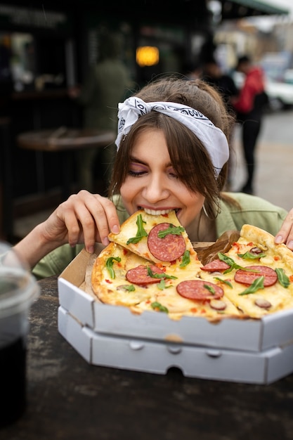 おいしいピザを持つ正面図の女性