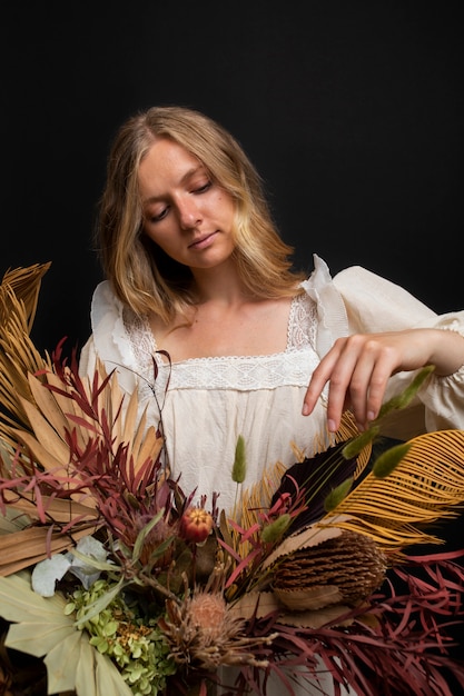 Front view woman with dried plants