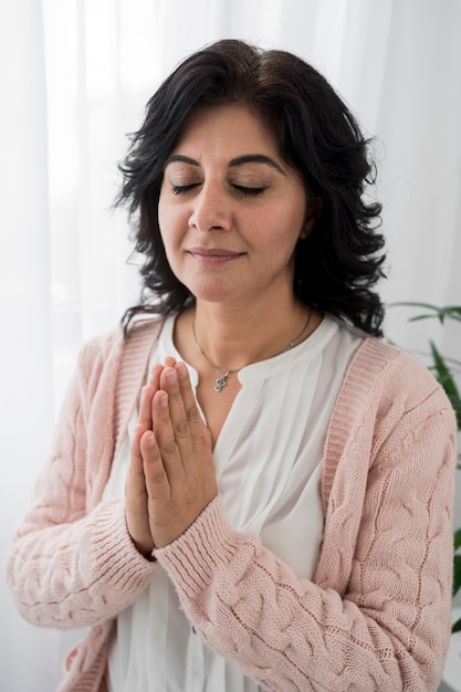 Free photo front view of woman with eyes closed praying