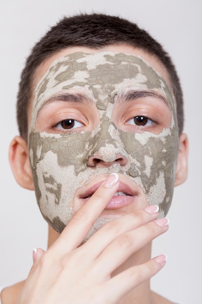 Donna di vista frontale con la maschera che esamina il primo piano della macchina fotografica