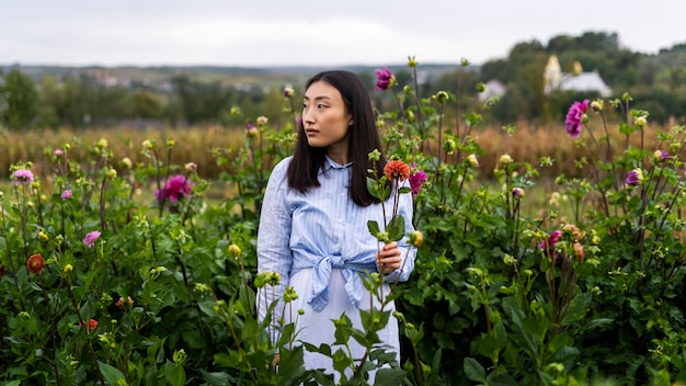 Foto gratuita donna di vista frontale con i fiori all'aperto