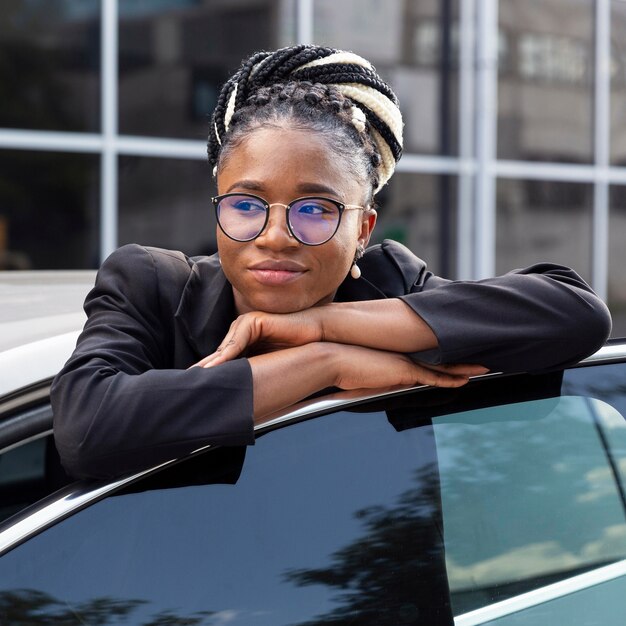 Front view of woman with glasses resting her head on car door