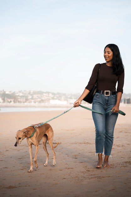 屋外でグレイハウンド犬を持つ正面図の女性