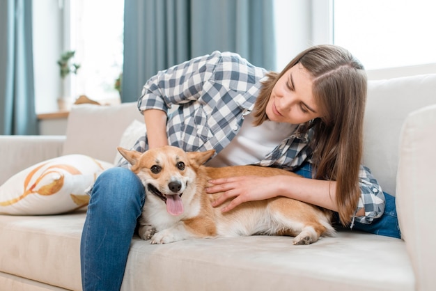 ソファの上に彼女の犬を持つ女性の正面図