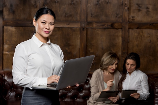 Foto gratuita donna di vista frontale con il computer portatile alla riunione