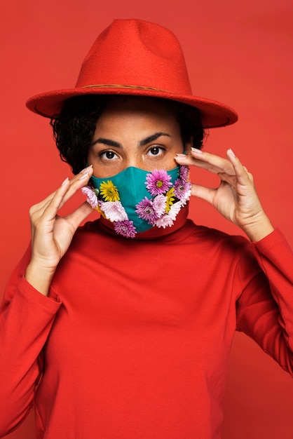 Foto gratuita vista frontale della donna con maschera e fiori