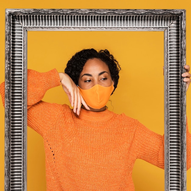 Free photo front view of woman with mask and frame