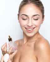 Foto gratuita vista frontale della donna con la bottiglia di profumo