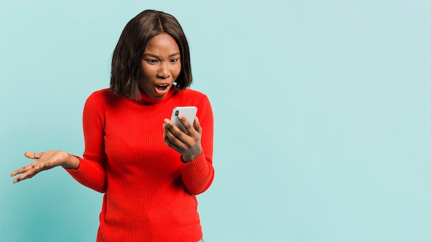 Front view woman with smartphone in studio