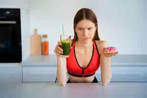 Free photo front view woman with smoothie and doughnut